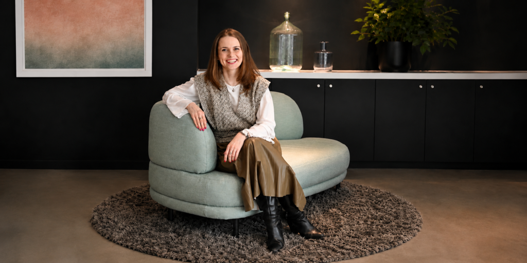 Coach Monika Matuszewska from LaMatu Professional Coaching Services sitting in an armchair in her coaching practice in Amsterdam